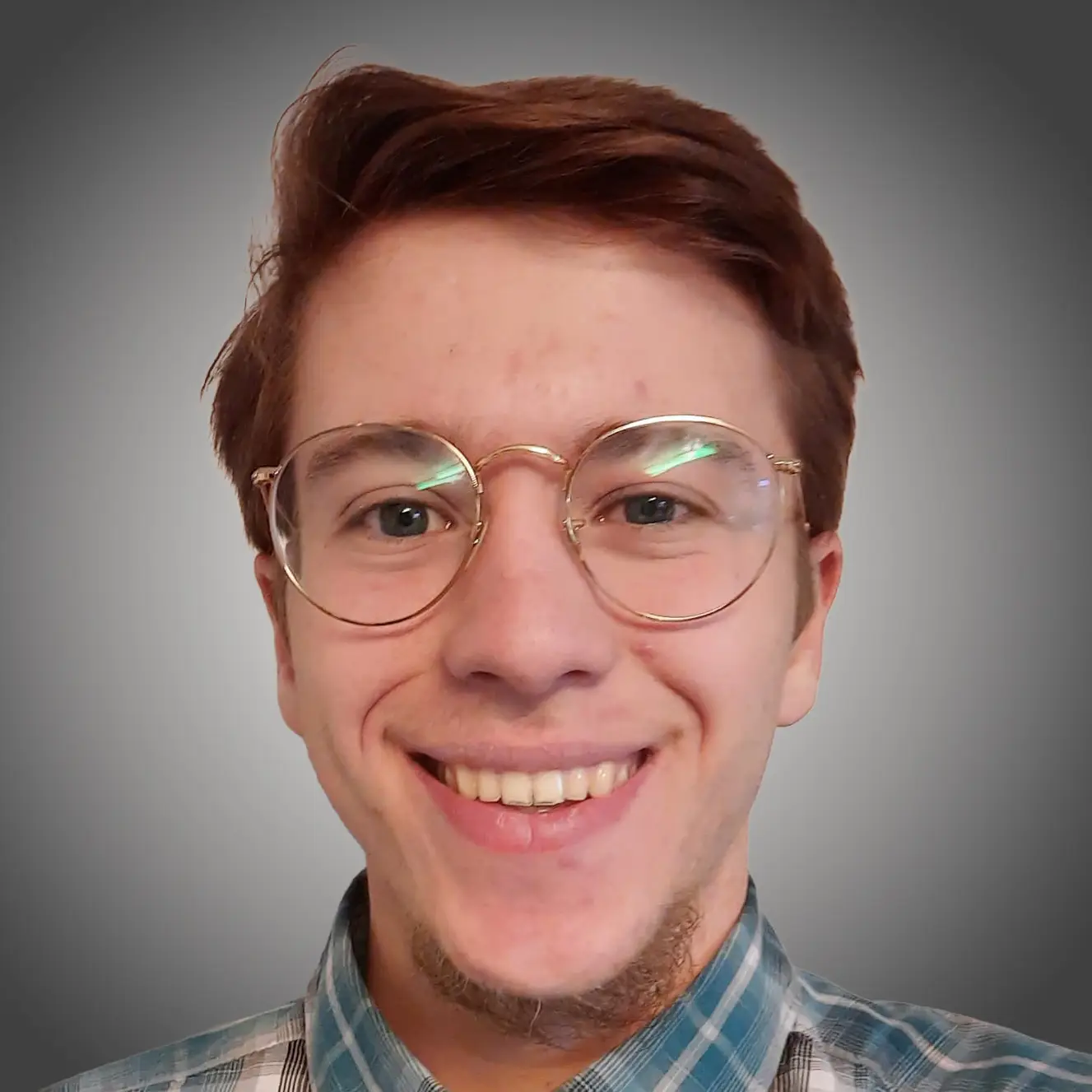 Porträt eines lächelnden Mannes mit Brille und kariertem Hemd