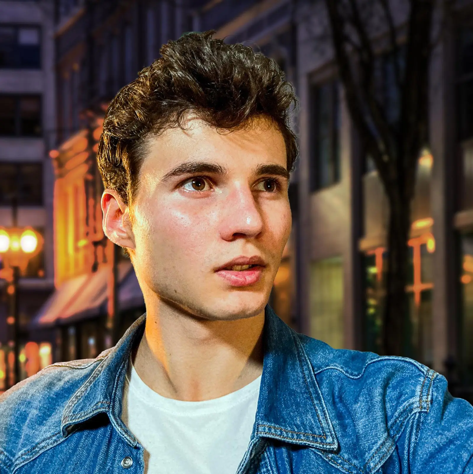 Portrait von Aaron Haller mit weissem T-Shirt und blauer Jeansjacke.